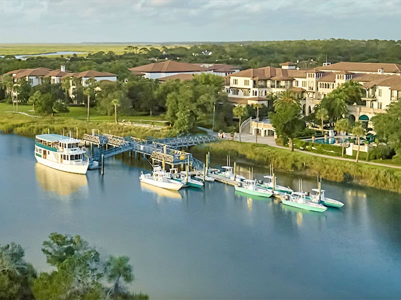 boats moored in a river near a resort