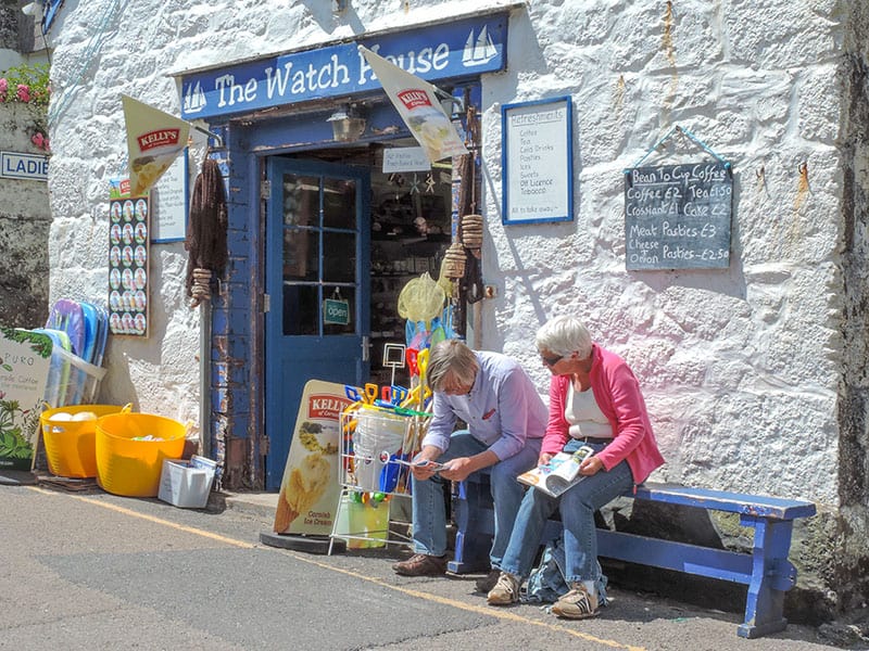 a coiple sitting on a bench outside a shop