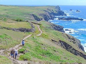 people on a hiking train on cliffs above the sea