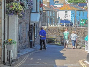 3 people walking along a quiet street