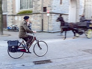 a man on a bicycle seen during November, one the best times to visit Bruges