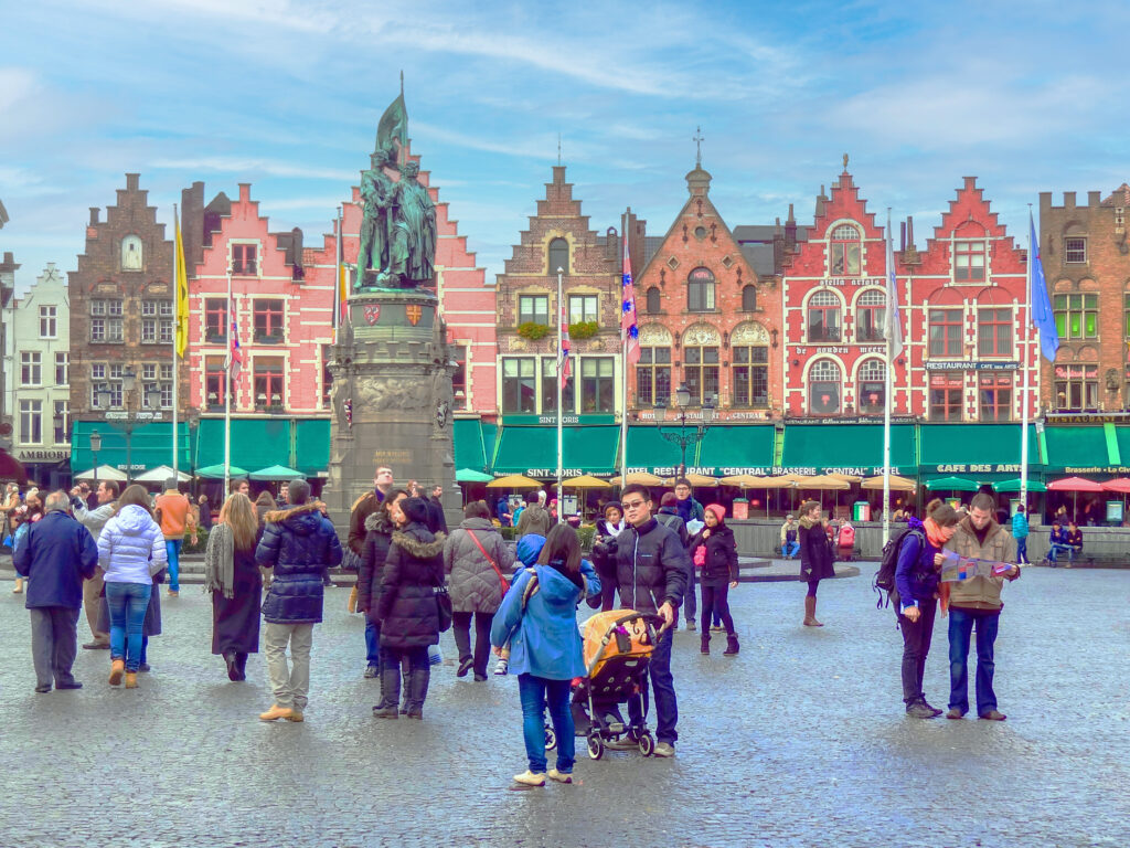 people in a colorful outdoor market during one of the best times to visit Bruges