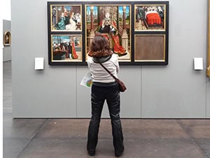 a woman looking at a painting in a museum