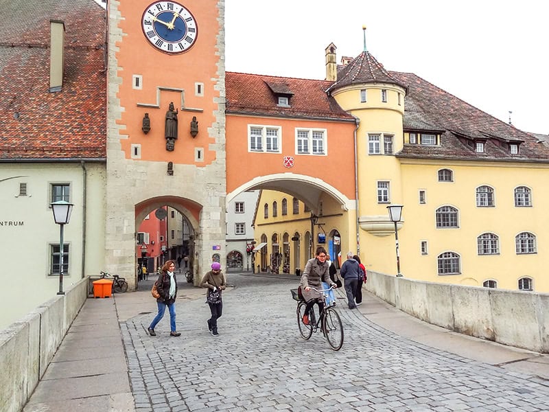 a woman on a bicycle near colorfully painted buildings