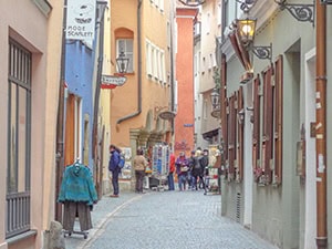 people walking down a street with colorful buildings