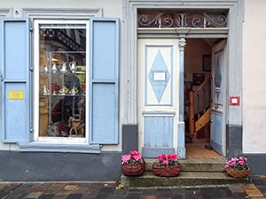 a shop with blue shutters and flowers