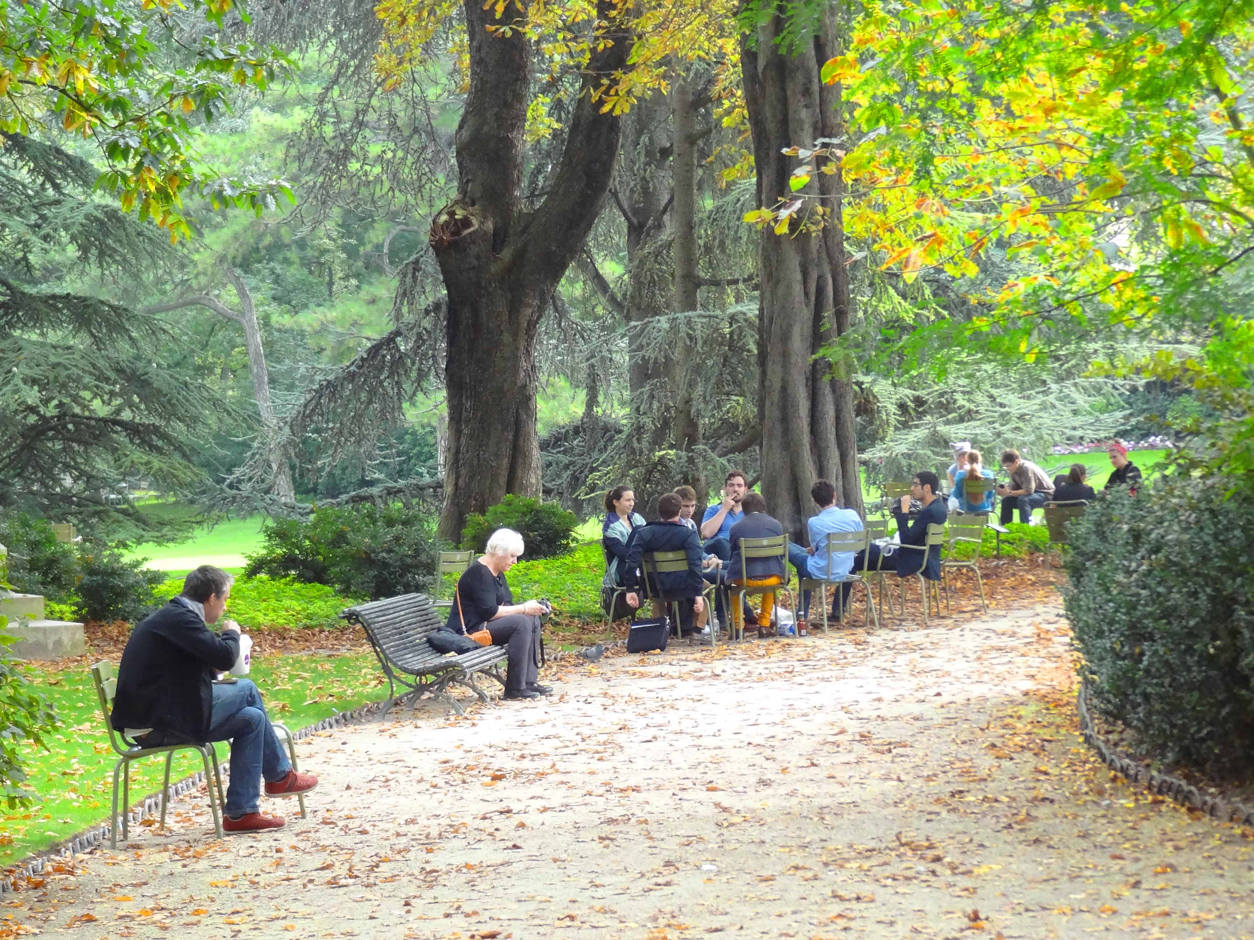 people sitting on a park path - paris itineraries and paris map