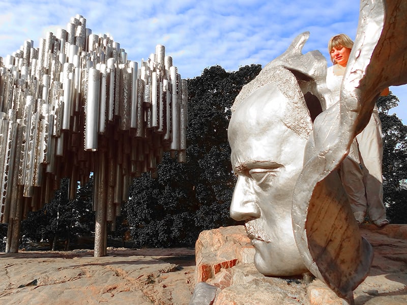 a woman looking at a scuplture on a monument