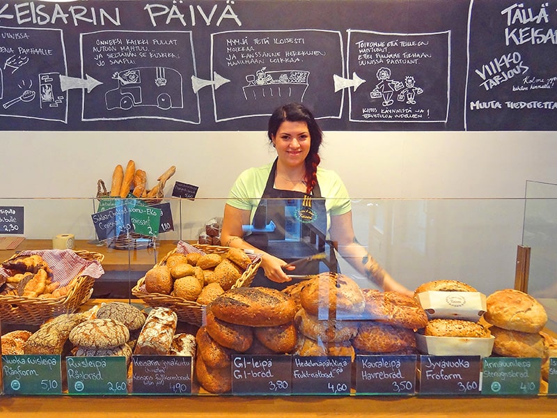 A young woman with loaves of bread in a bakery