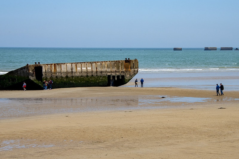 Remnants of the Mulberry Harbors on the beach and in the sea at Arromanches-les-Bains seen on a trip to Normandy from Paris