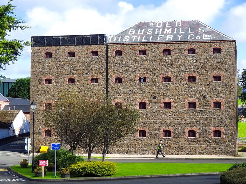 a man walking by a brewery building on the Northern Ireland Coast