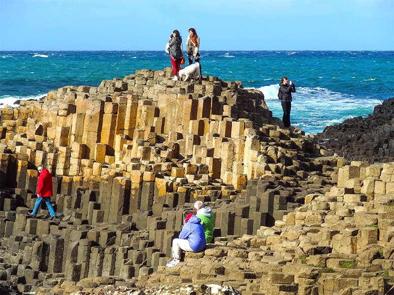 people on large columns of stone on the Northern Ireland Coast