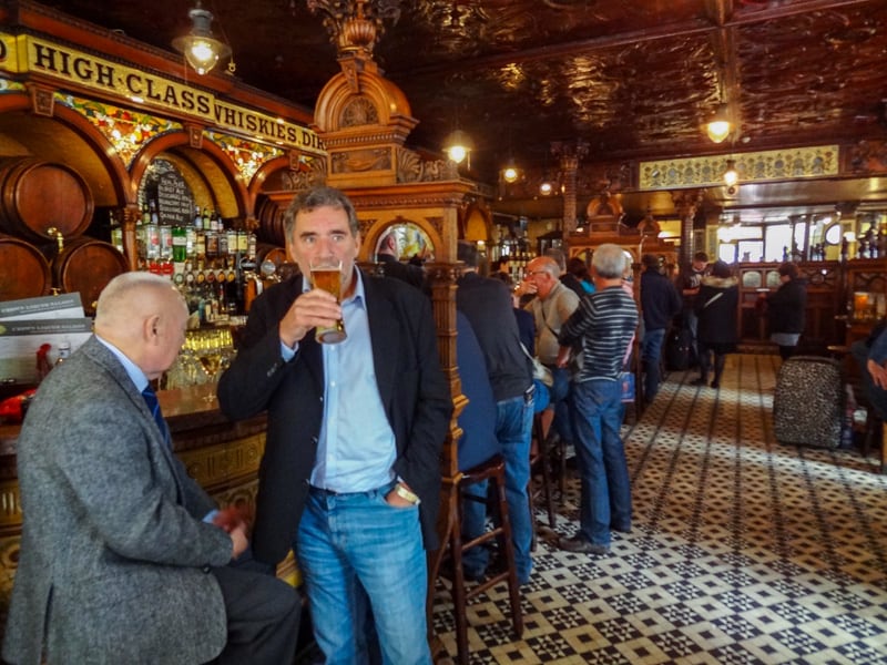 Men standing by a bar drining beer in an ornate pub and restaurant