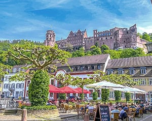 an outdoor cafe under a large castle on a hilltop