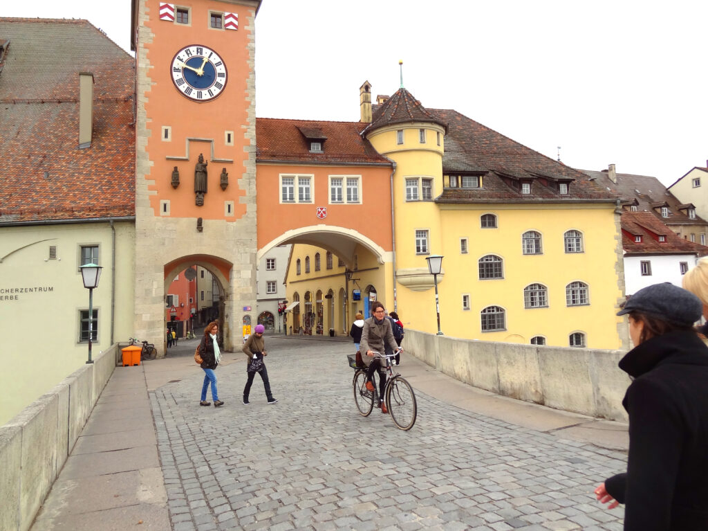 a bicyclist passing colorful buildings in one of the places to visit in Bavaria
