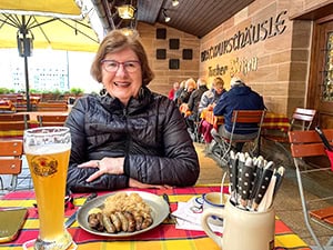 a woman enjoying a beer and wurst on a Viking river cruise Paris to Prague