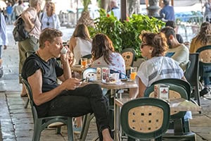 people having breakfast in a cafe while seeing Sicily by car