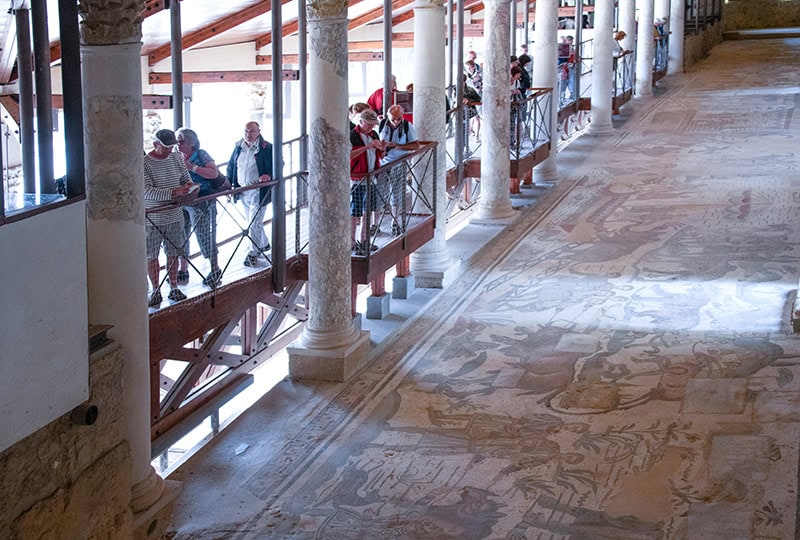 people looking at mosaics on the floor while seeing Sicily by car