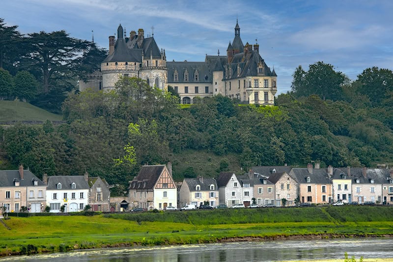 A chateau on a hill above a line of houses in the Loire Valley