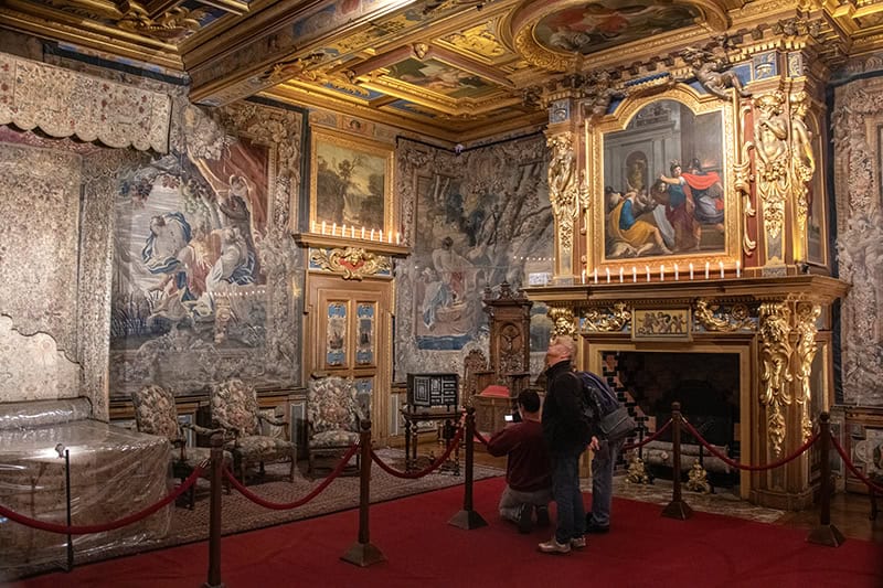 people looking at tapestries and golden woodwork in a chateau in the Loire Valley