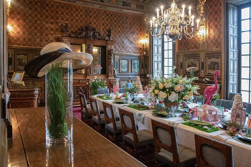 an exhibit of an ornate dijning room table and chandelier