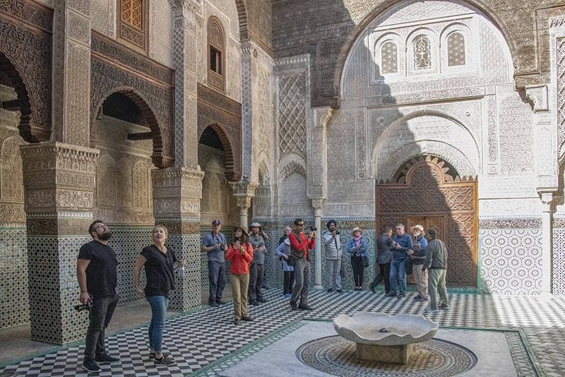 people in front of a fountain in a large religious building