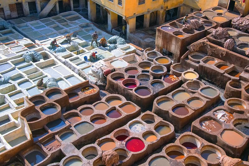 men working in huge colorful leather dying pits in Fez Morocco