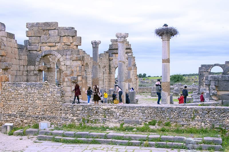 people walking about the ruins in an old Roman city