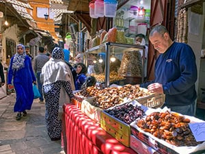 a man selling vegetables in a market in Fez Morocco