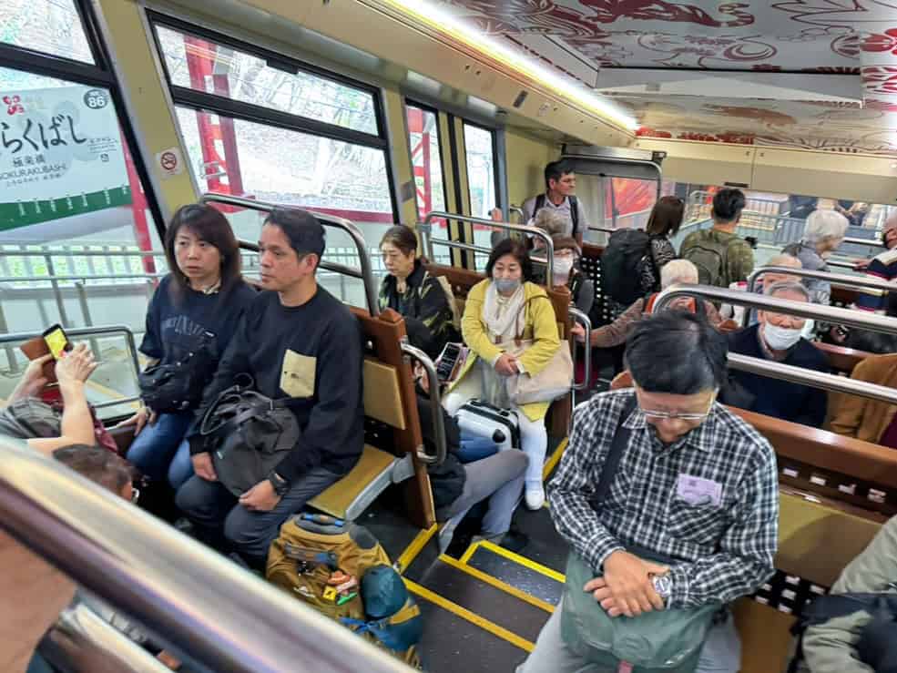 people sitting in a cable car going up a mountain side