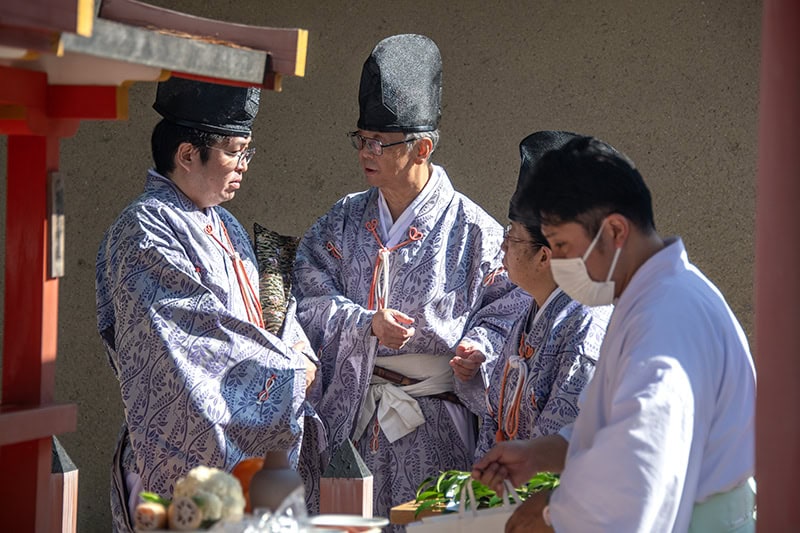 3 monks standing by a table talking