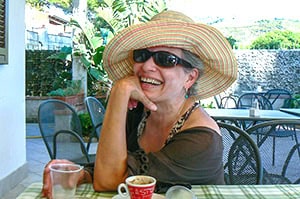 Maria Lisella sitting at a table enjoying coffee