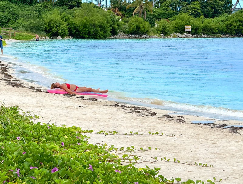 a woman in a red bathing suit nappingcon the beach shore