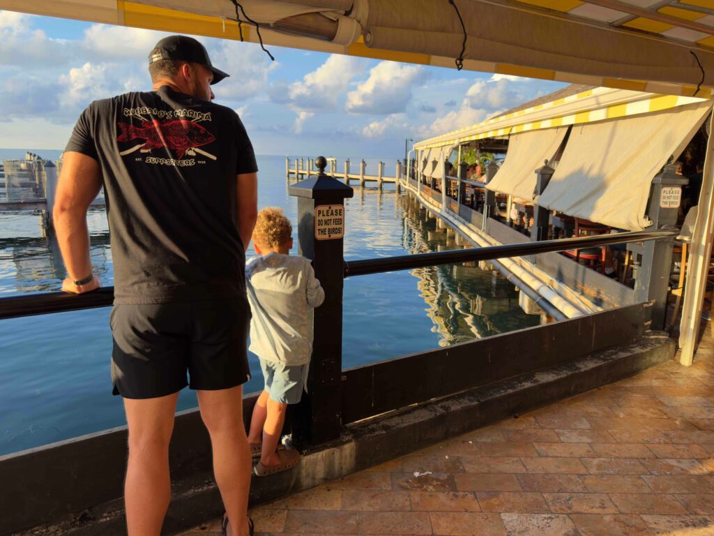 A father and child looking at a harbor during a road trip in the Florida Keys