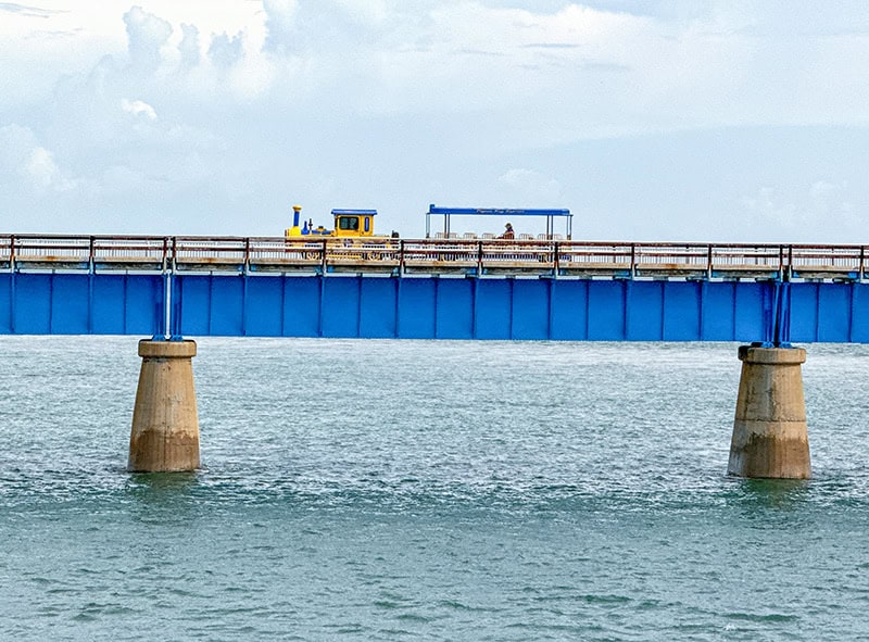 a yellow train on a bridge