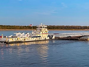 a tow boat and barges seen on a cruise on the Mississippi