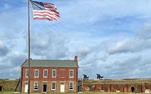 a US flag flying above an old fort