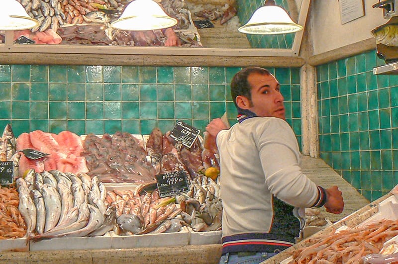 a fishmonger looking over his shoulder at customers